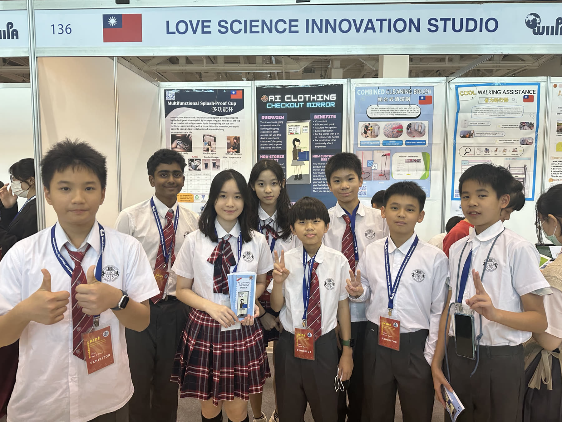 The HCAS team at their KIDE 2024 booth with invention posters behind them