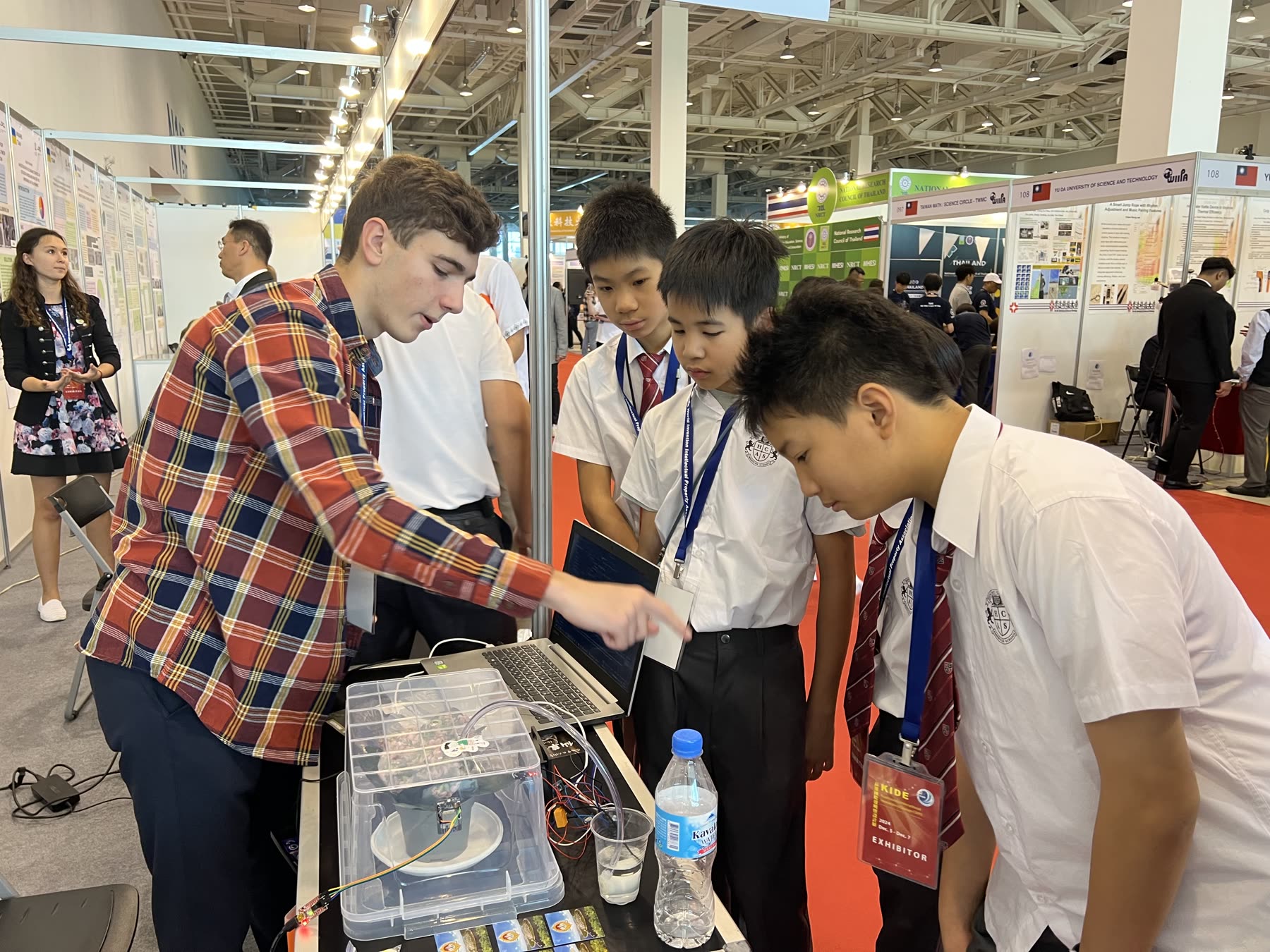 HCAS students demonstrating a prototype and laptop to a visitor at the 2024 expo